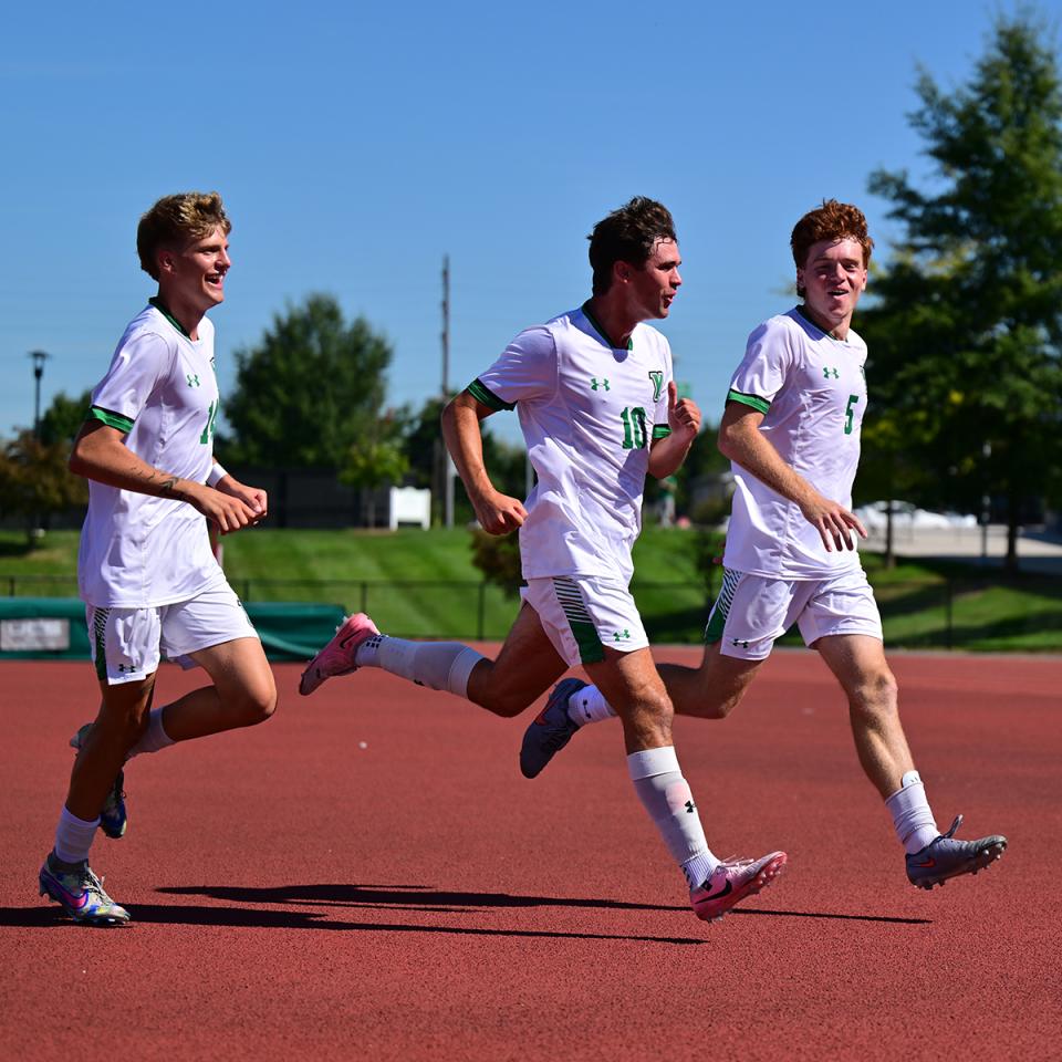 Three players of the YCP men's Soccer team run off the field