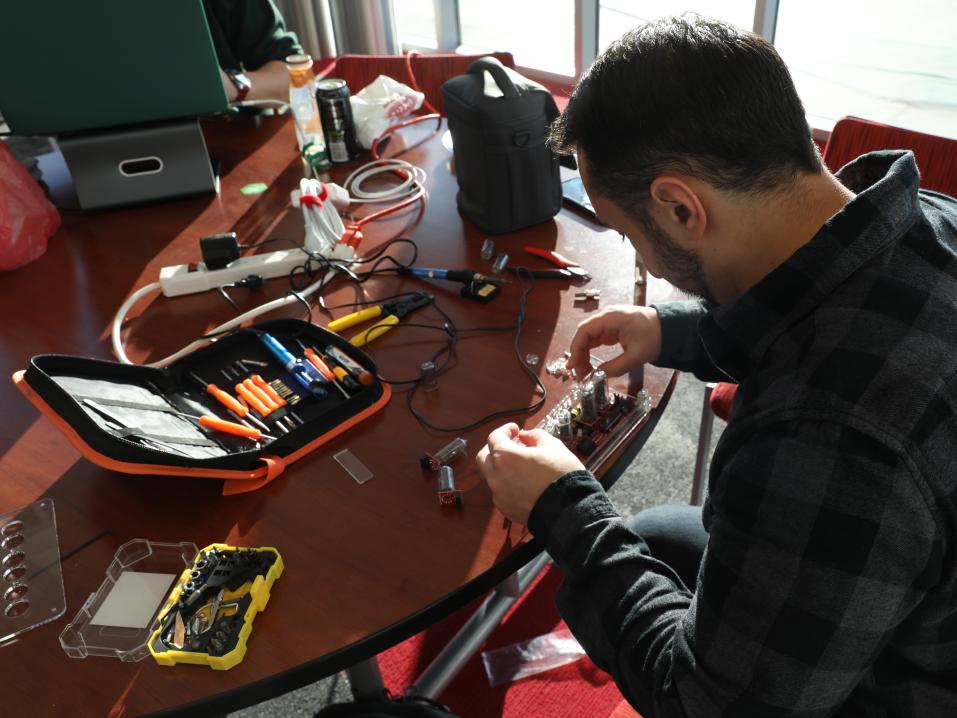 A student sits at a table with wires during the YCP Hackathon