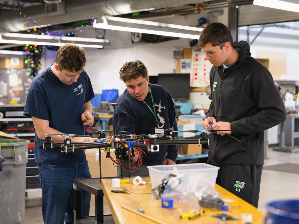 Students work together to build and test a drone in an engineering lab.