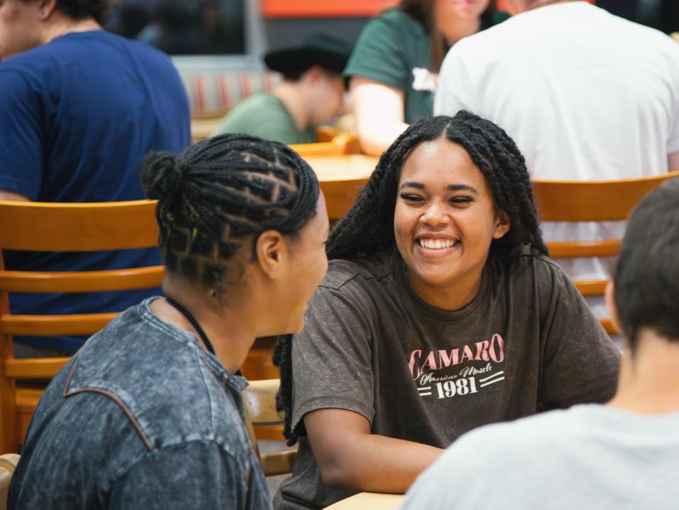Two students sitting together in the dining hall
