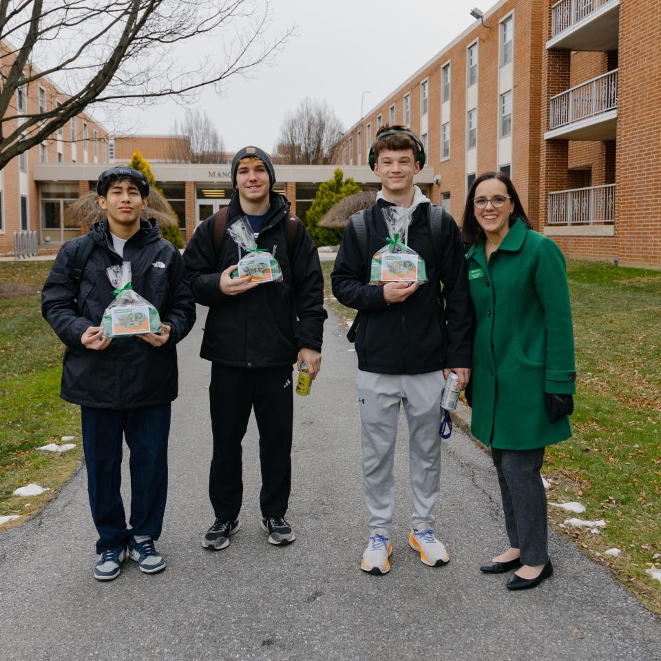 Three students and a staff member pose with SpartaGrams