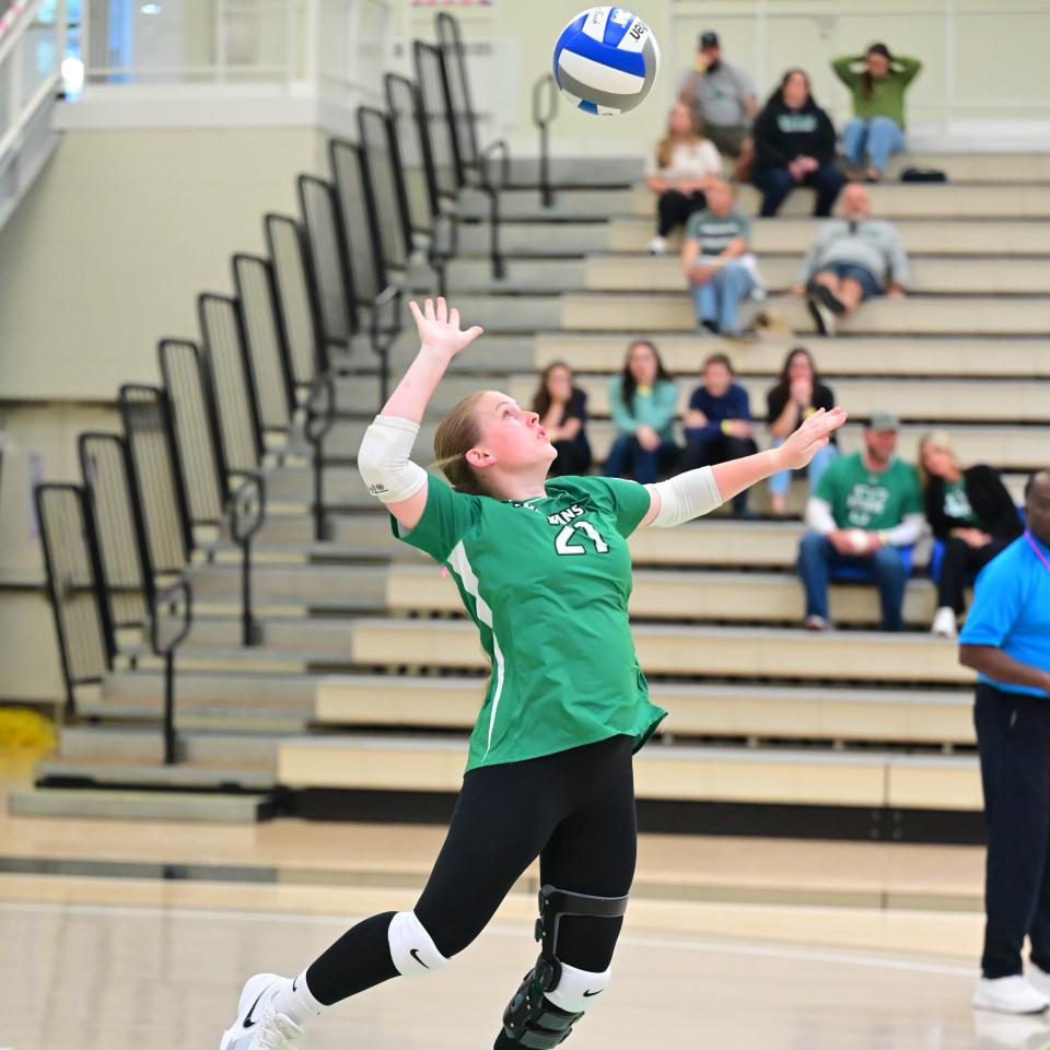 A YCP volleyball player spikes the ball.