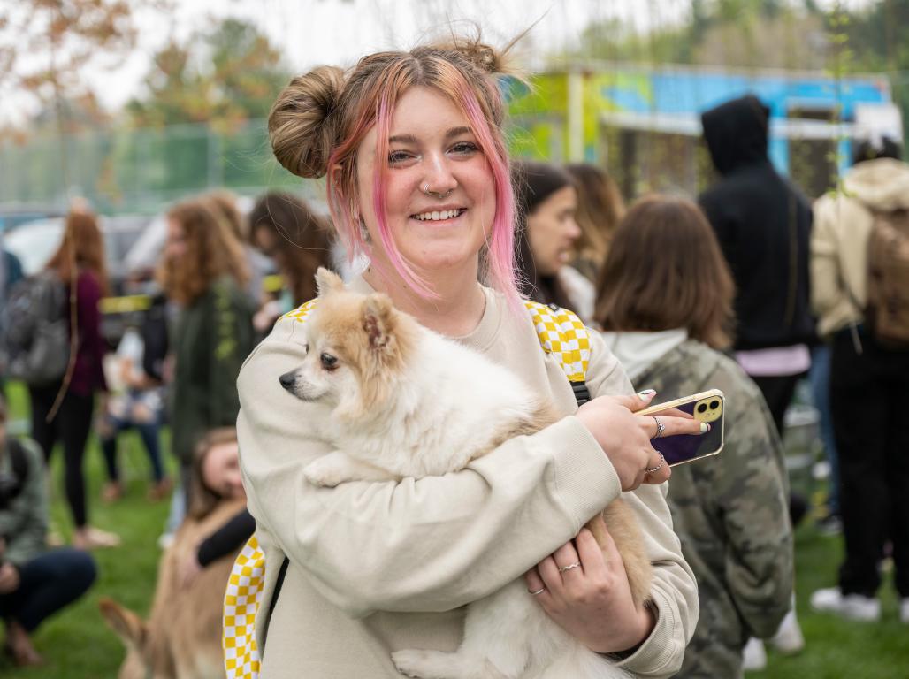 A student holding a dog.