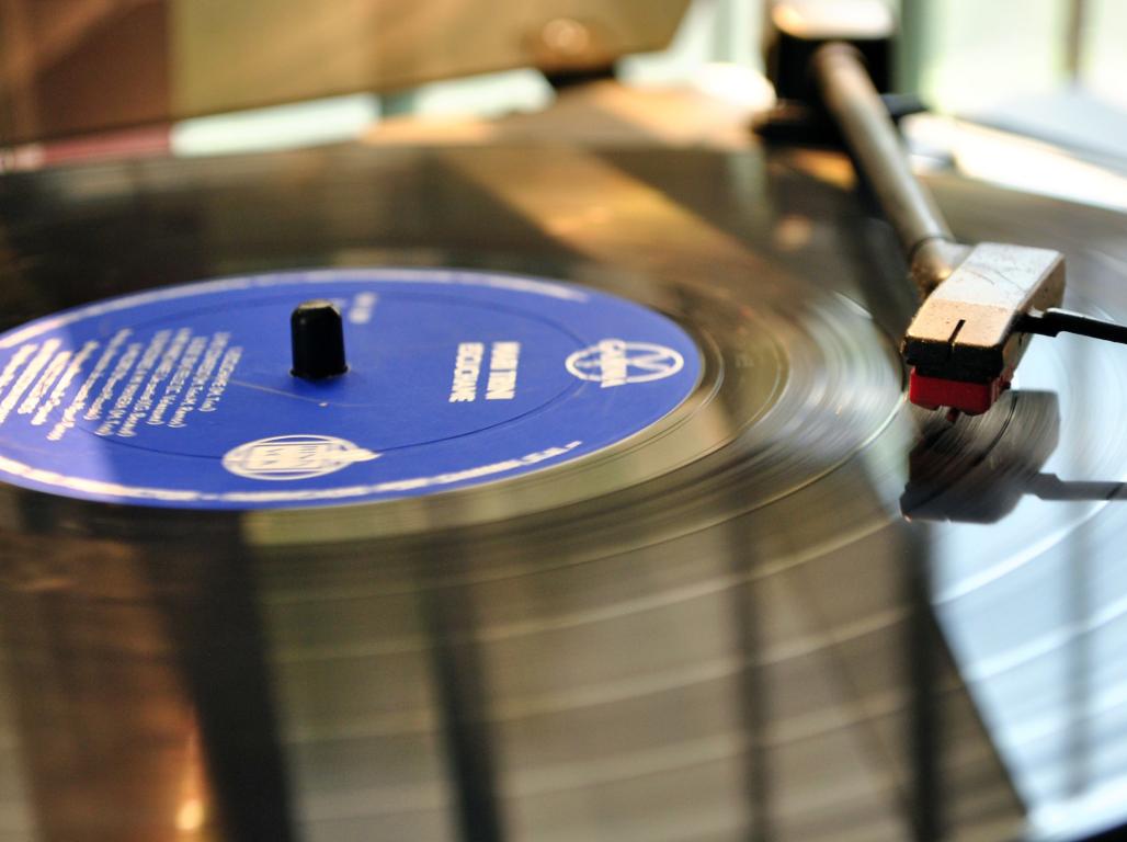 A vinyl record spins on a turntable.