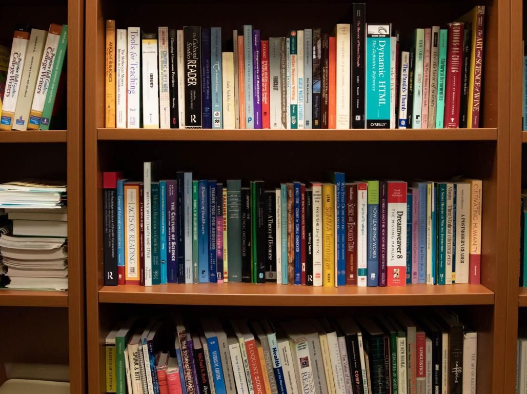 A five layered bookshelf with books.