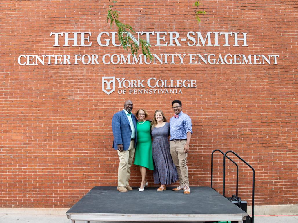 President Pamela Gunter-Smith, JL Smith, and two family members post under a sign reading The Gunter-Smith Center for Community Engagement.