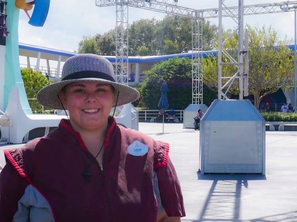 Lizzie Helmick working at Disney in a gray hat.