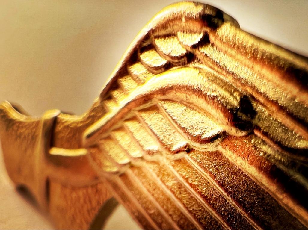 A gold sculpture of a winged sandal.