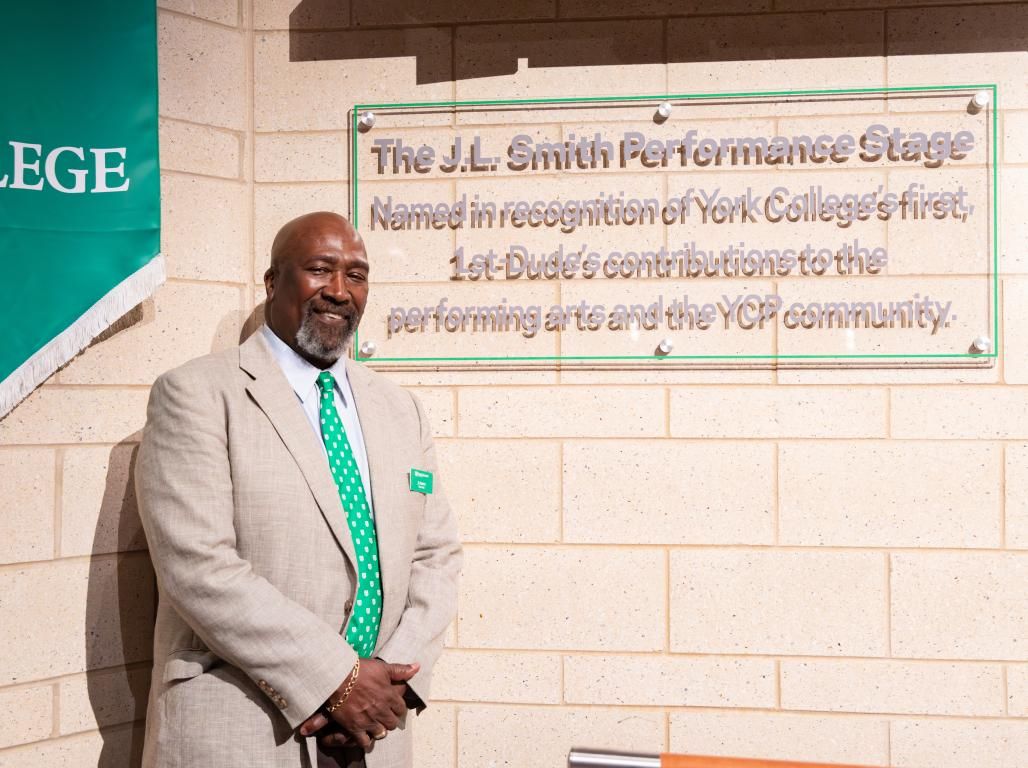 J.L. Smith posing next to the stage dedicated to him