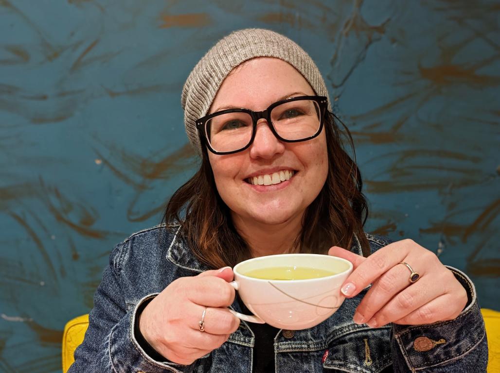 Jenn Strang smiles as she sips a cup of tea.