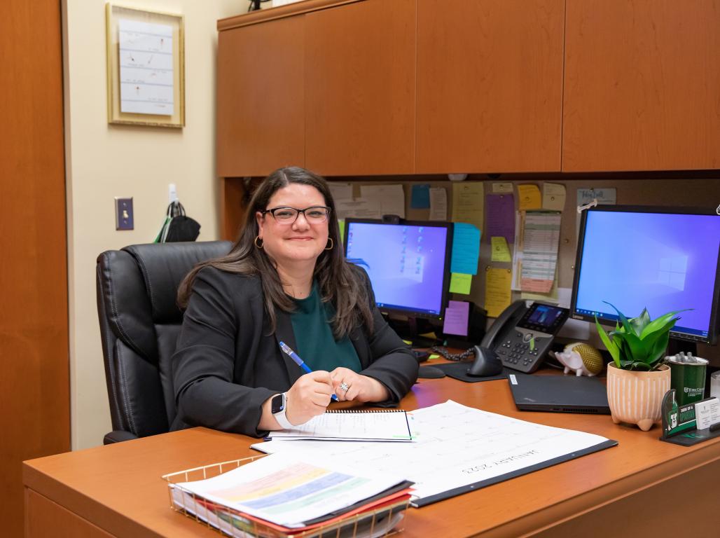 Julie Rasmuson smiles from her seat behind the desk in her campus office.