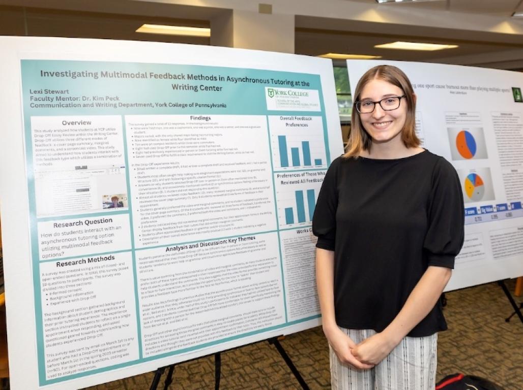Lexi Stewart stands next to her research poster. 