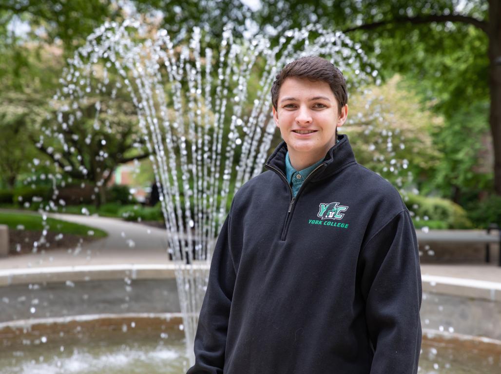 Nick Barry stands in front of a fountain on campus.