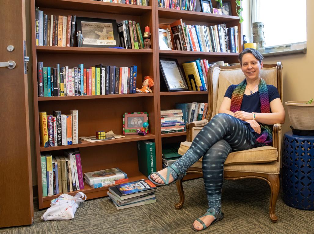 Randi Shedlosky-Shoemaker, sitting by a bookcase in her office.