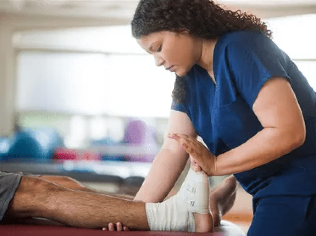 A physical therapist works on a patient's foot and ankle stretch.