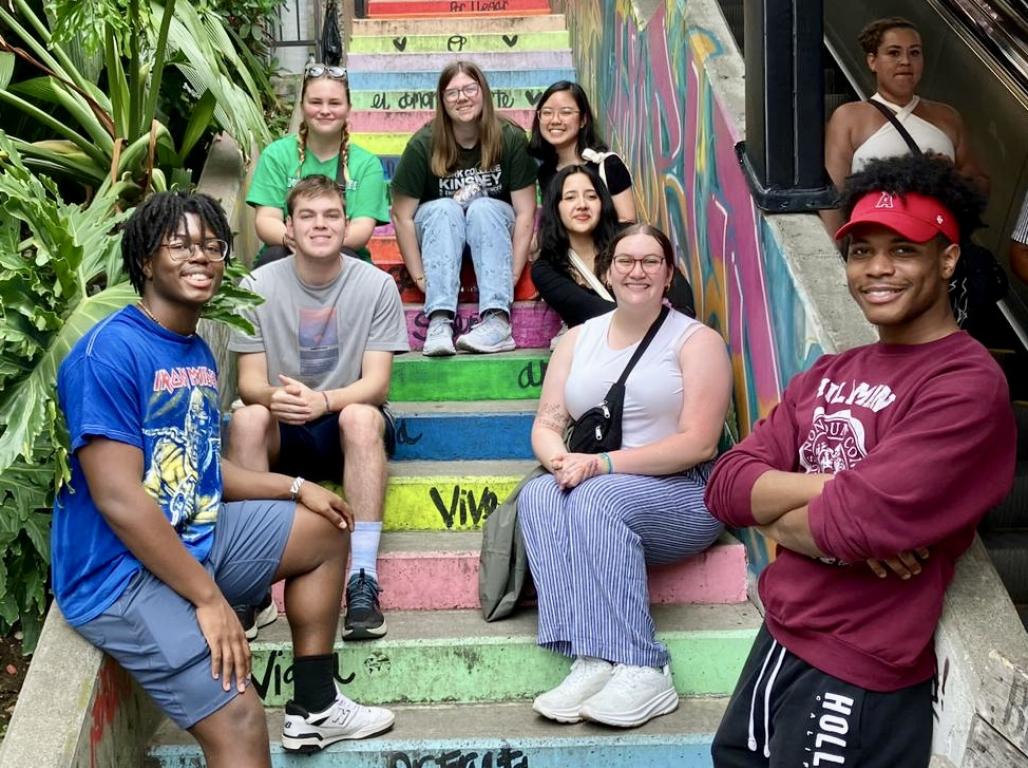 A group of students on the Colombia Study Abroad Trip sitting on a colorful staircase.