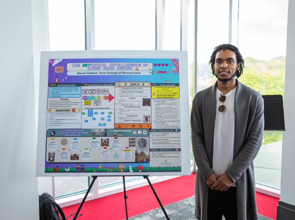 Devon Tolbert standing next to his research poster at a research showcase in Yorkview Hall.