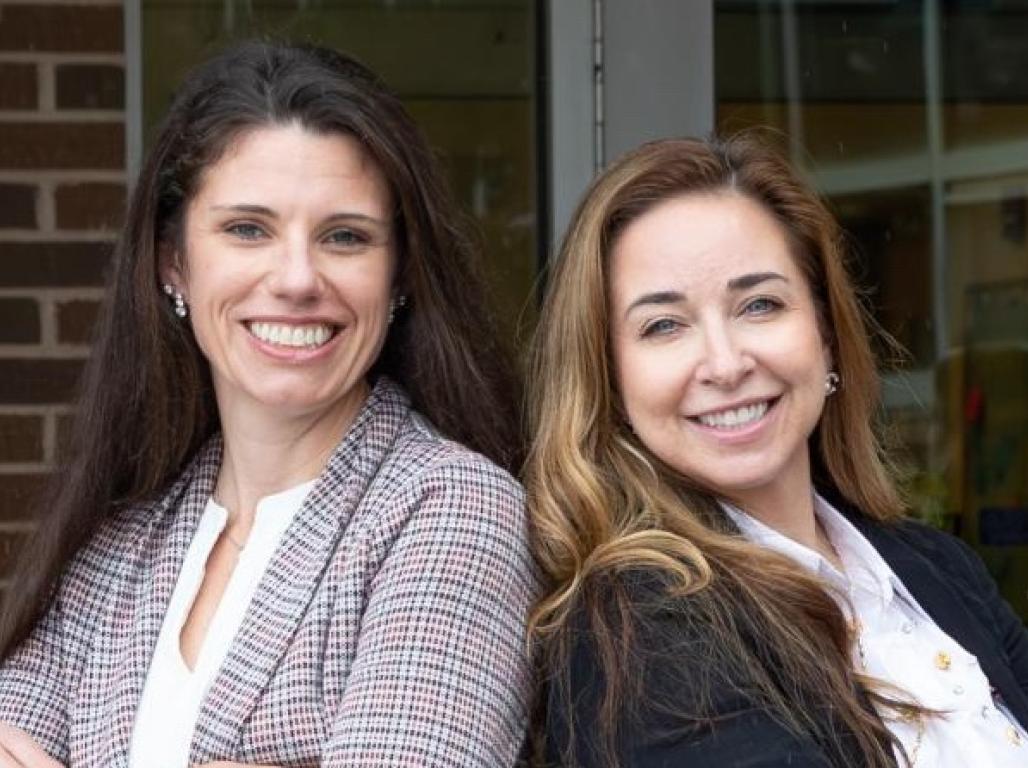 Drs. Amy Red and Rachael Lattanzio standing back to back with their arms crossed.