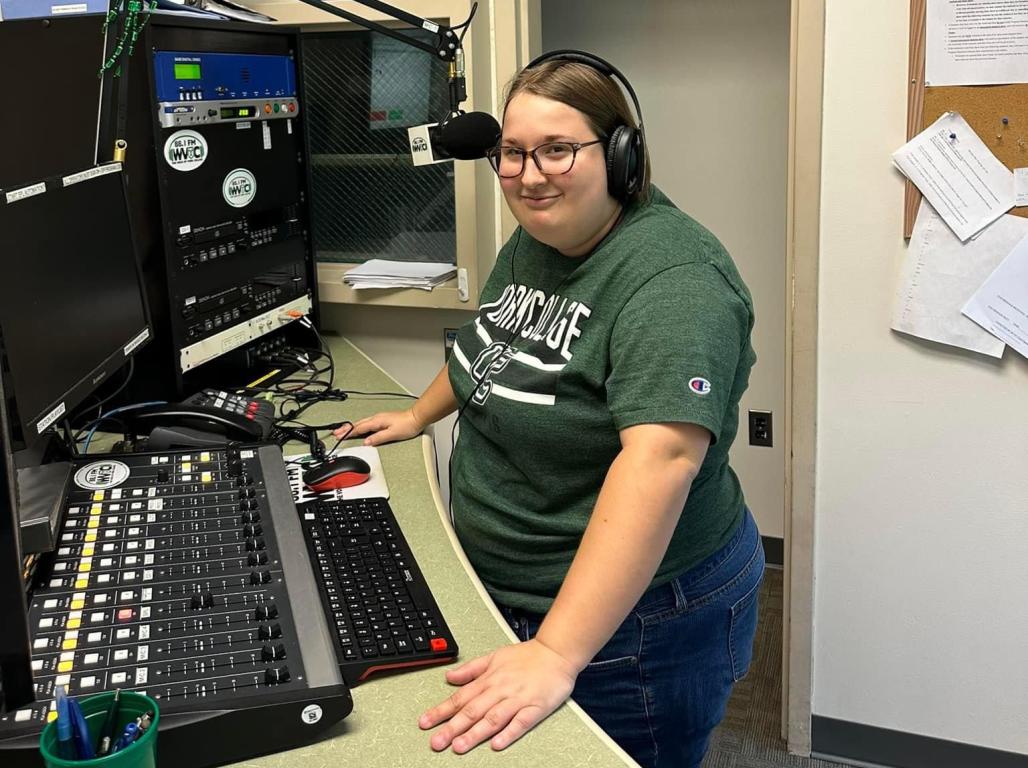 Kate Barrelle stands behind equipment in the radio station at York College.