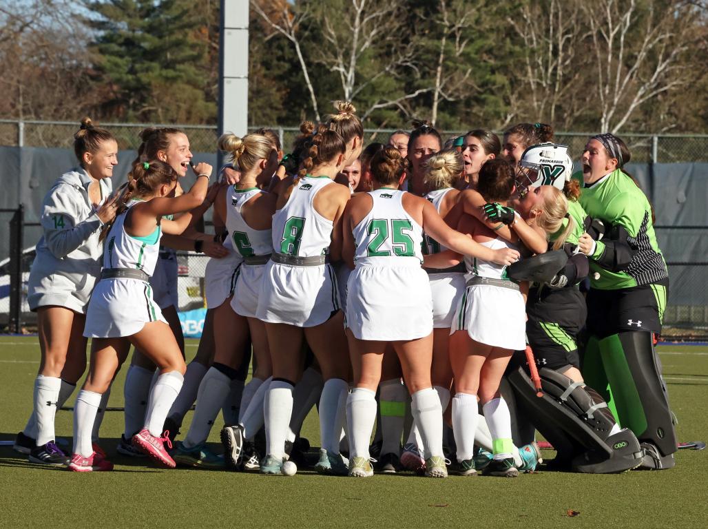 York College Field Hockey players celebrating together on the field