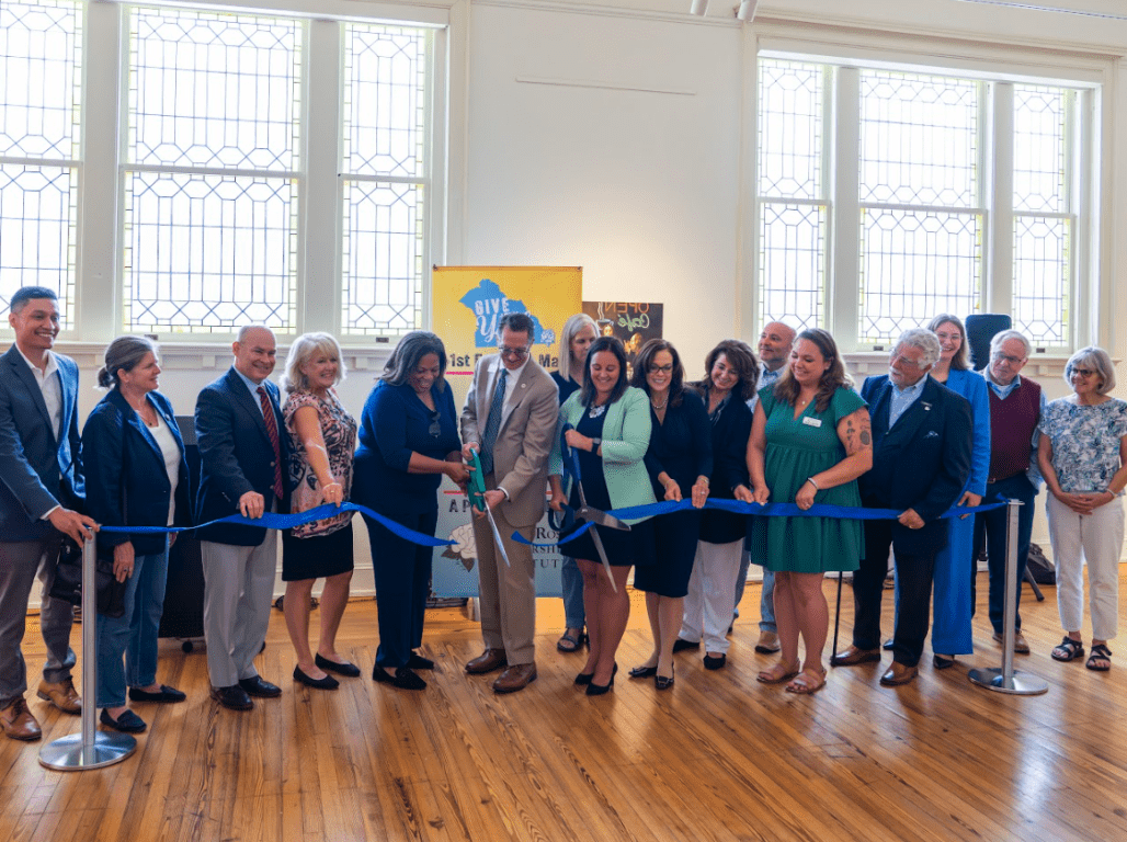 A wide shot of a group of people at Marketview Arts cutting a ribbon