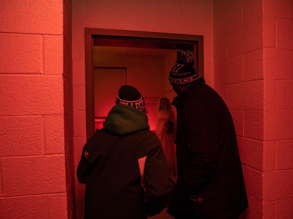 Two people peering into a room illuminated red.