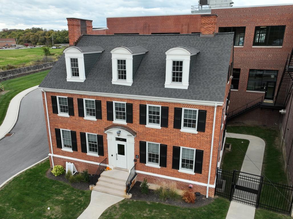 Exterior view of Diehl House taken from a drone. Brick building with green front lawn.