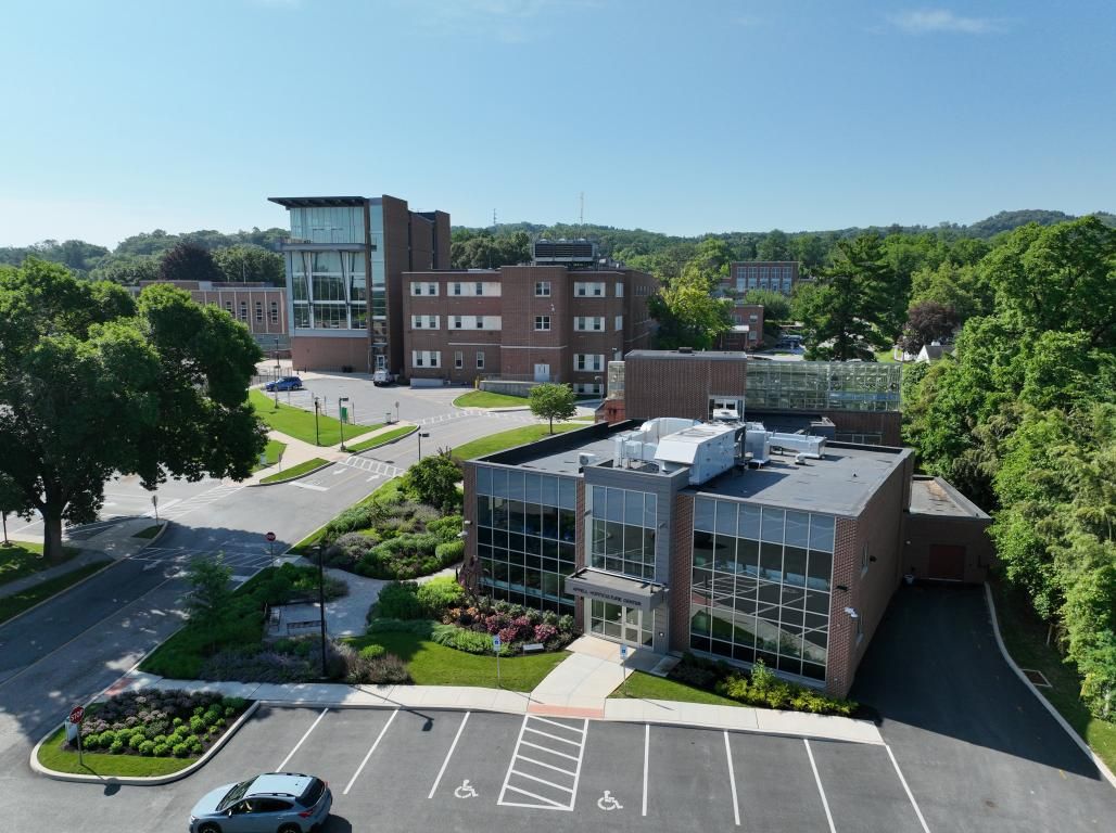 Aerial view of York College’s Appell Horticulture Center, including surrounding landscaped gardens, campus buildings, trees, and parking areas.