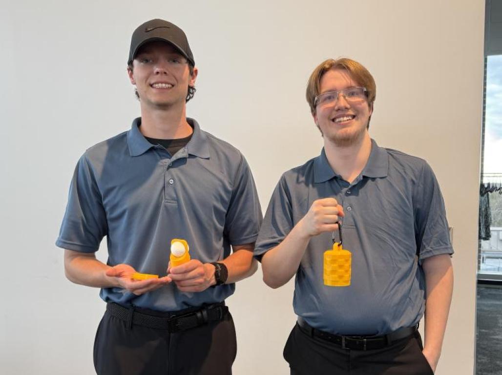Two students stand together with a product they created.