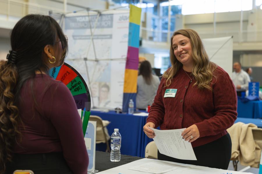 An alumn talks with students at the career expo.