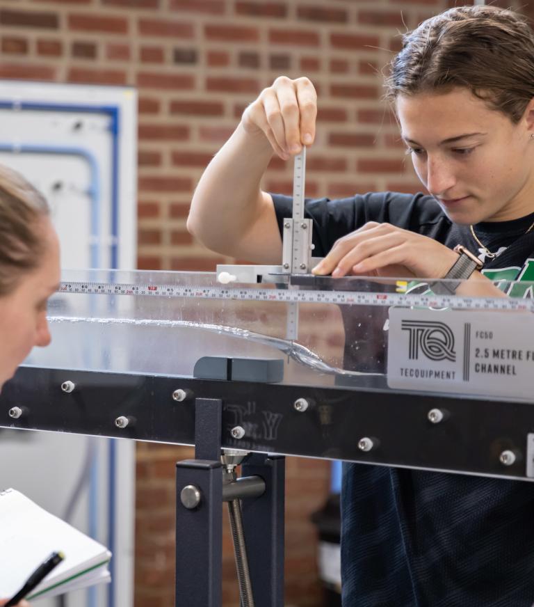 Two students are studying water flow in the Kinsley Engineering Center
