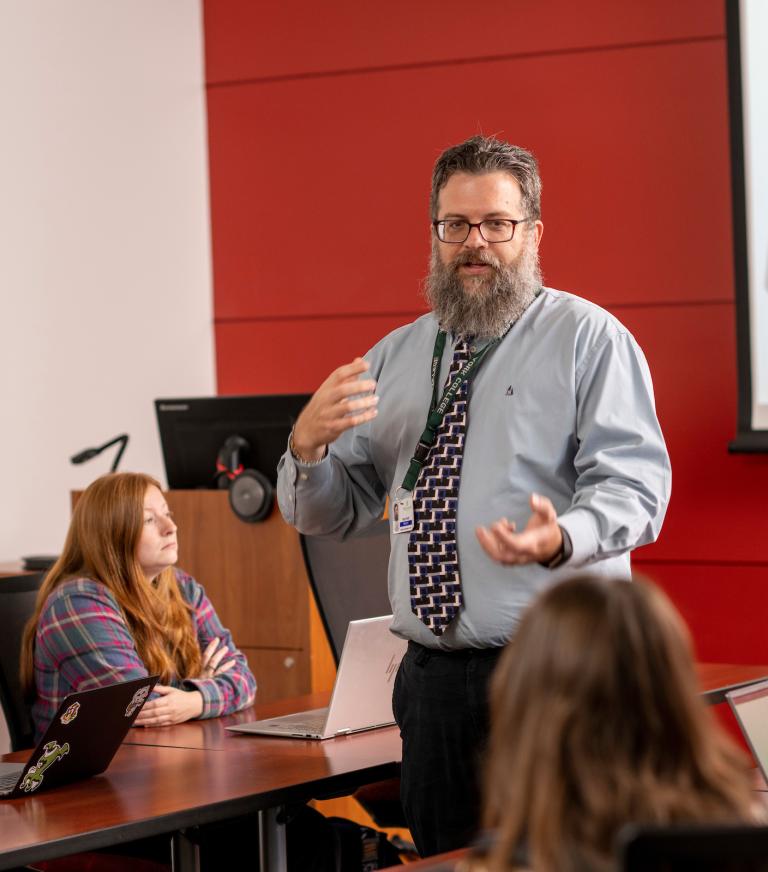 A professor speaking to a group of students.