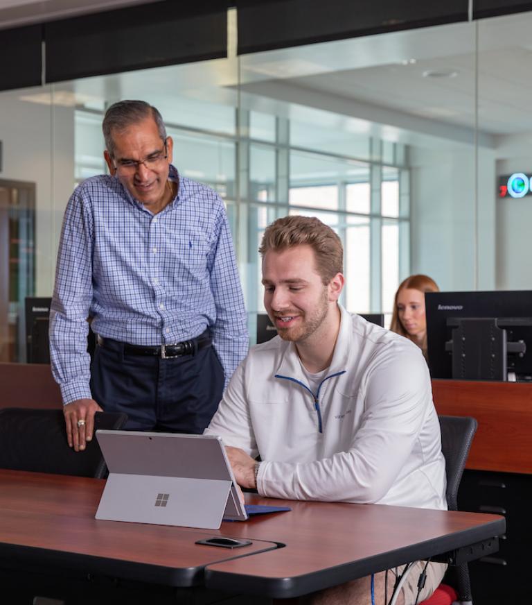 A student and a teacher in a business classroom.