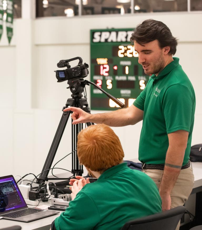 Two Sport Management students filming a York College basketball game.