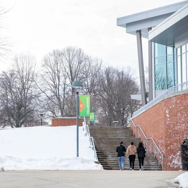 Students walk up the outdoor steps beside the Performing Arts Center on a snowy day.