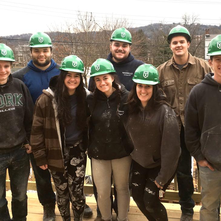 York College students with hard hats on observing a construction site
