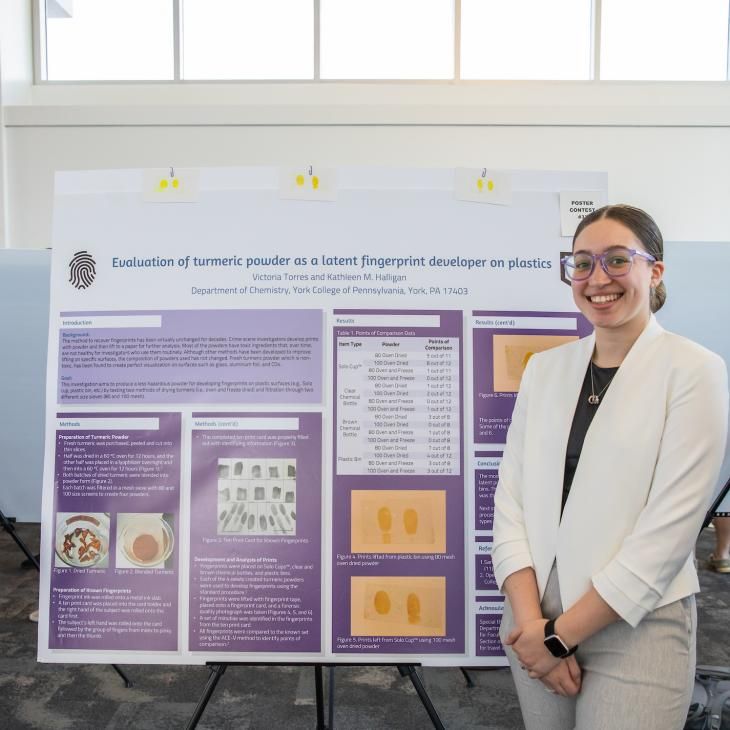 Student with their research poster at the Undergrad Research Showcase.
