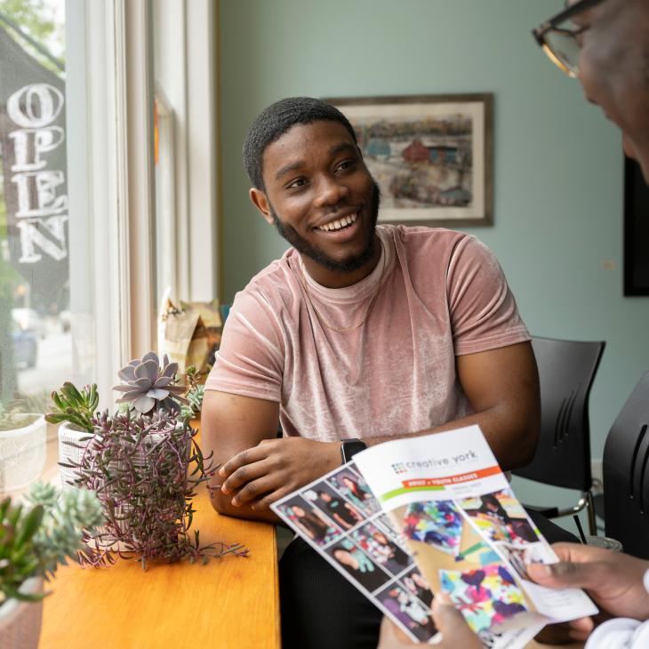 Photo of students inside Marketview Arts smiling and talking with each other.