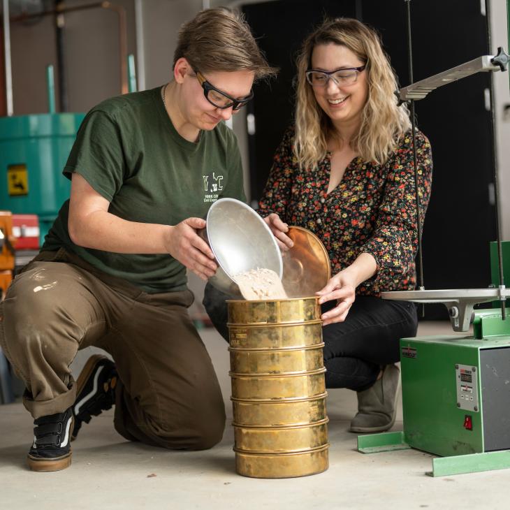 A Civil Engineering student performs an experiment with a professor.