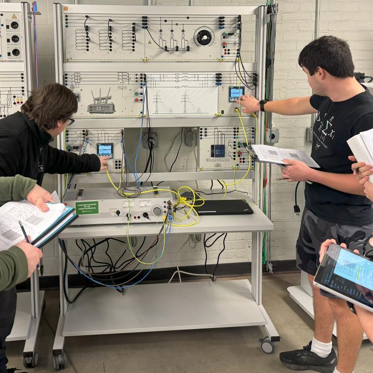 A group of students changing wires on a board
