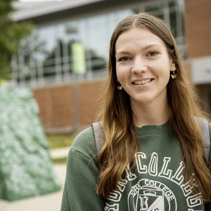 Sport Media major Bri Clary smiling at the camera in front of Ol' Spart.