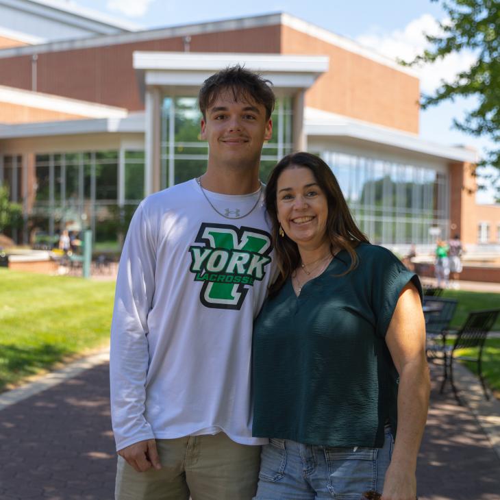 A parent and student stand together in front of the WPAC.