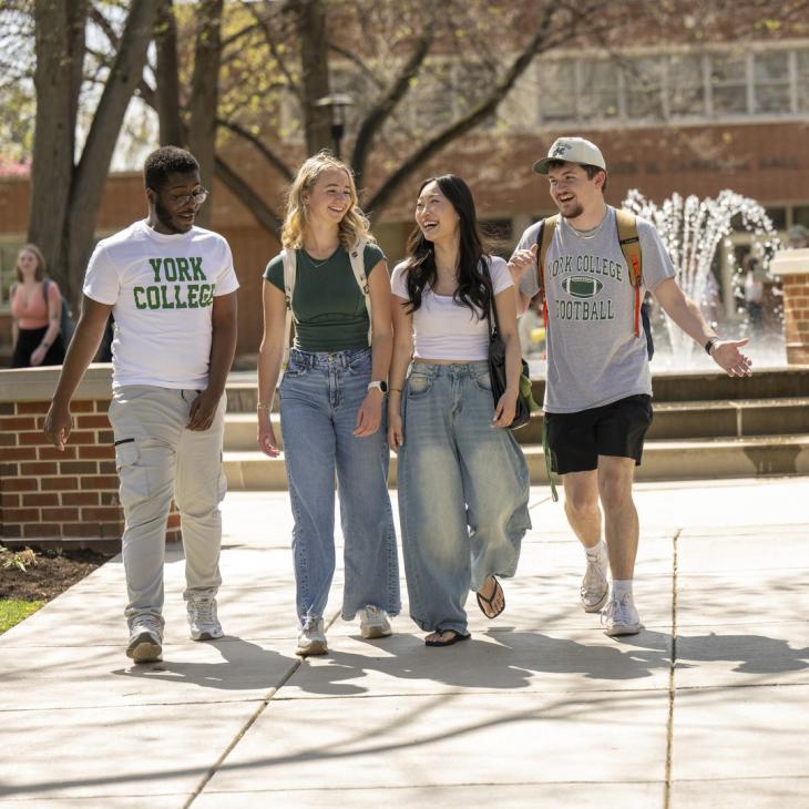 Students walking outside near the fountain