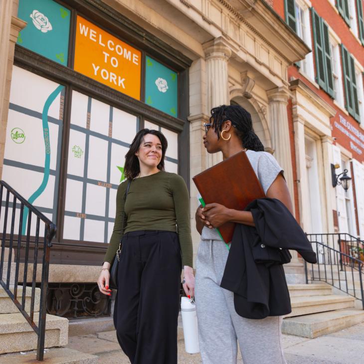 Two people walking in downtown York.