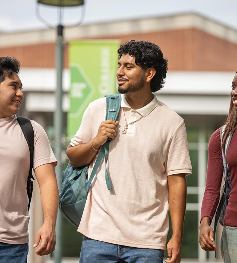 Three students walking together in front of the WPAC building