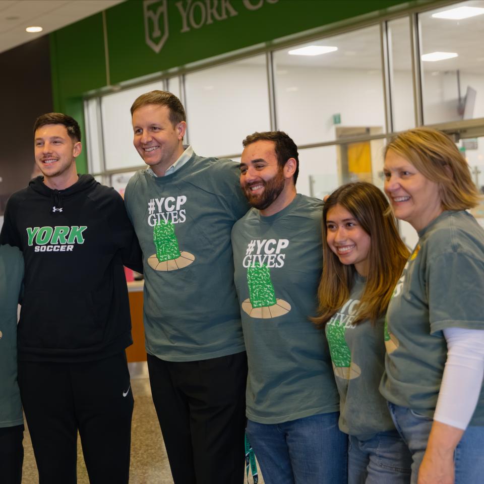 A group of students and faculty stand together with matching YCPGives shirts.
